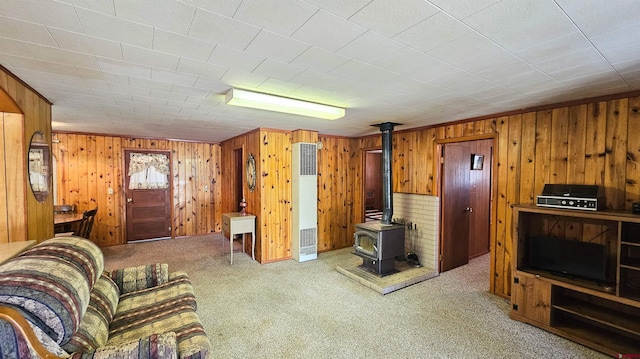 59 Willow St, South Fork, CO 81154 - living area with a heating unit, carpet flooring, a wood stove, and wood walls