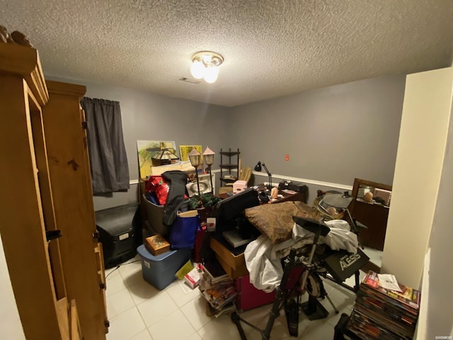 bedroom featuring light tile patterned floors and a textured ceiling