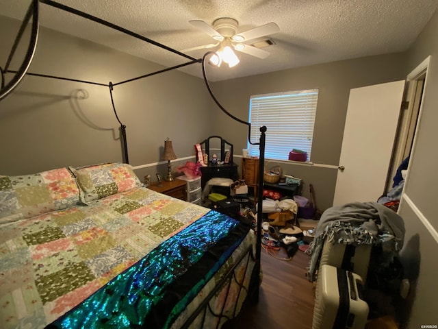 bedroom featuring dark wood-style floors, ceiling fan, and a textured ceiling