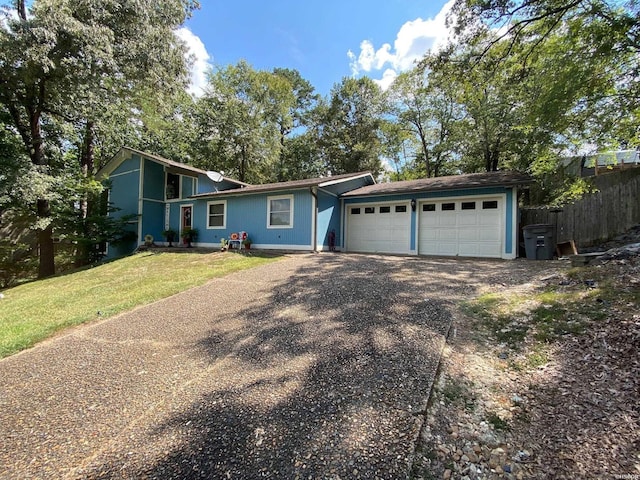 view of front of home featuring driveway, a front lawn, an attached garage, and fence