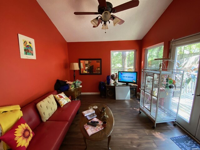 living room featuring baseboards, a ceiling fan, vaulted ceiling, and dark wood-type flooring