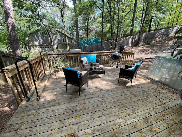 wooden terrace with a fenced backyard and an outdoor living space