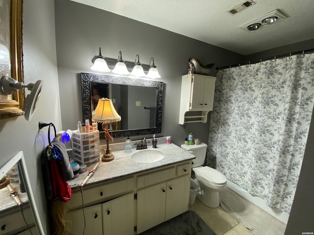 bathroom with visible vents, toilet, vanity, a textured ceiling, and tile patterned floors