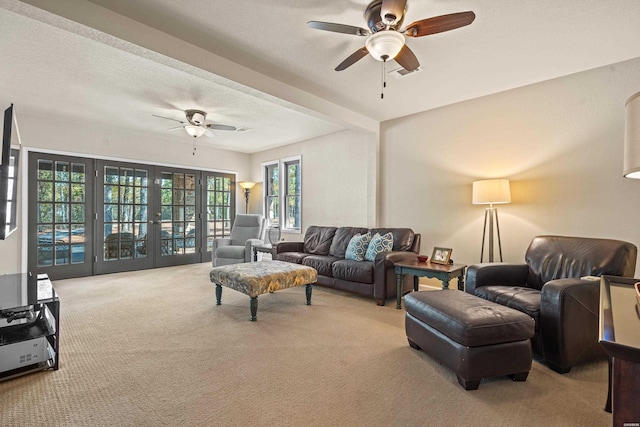 living room featuring french doors, light carpet, ceiling fan, and a textured ceiling