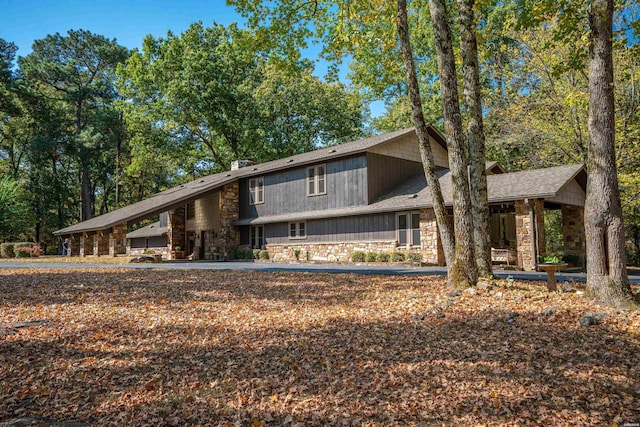 back of property featuring stone siding