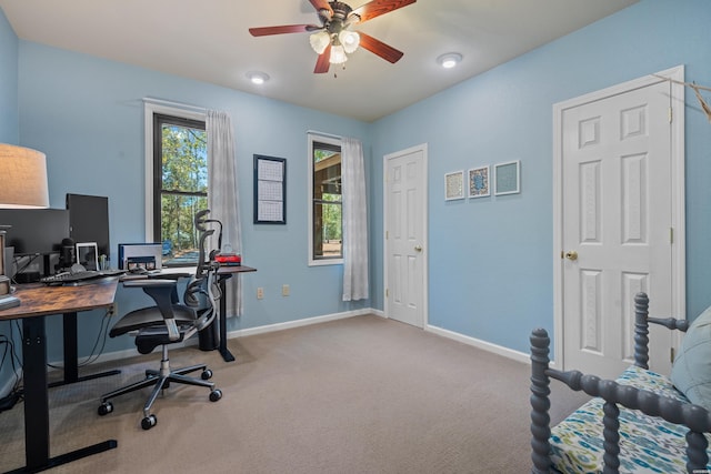 carpeted office featuring a ceiling fan and baseboards