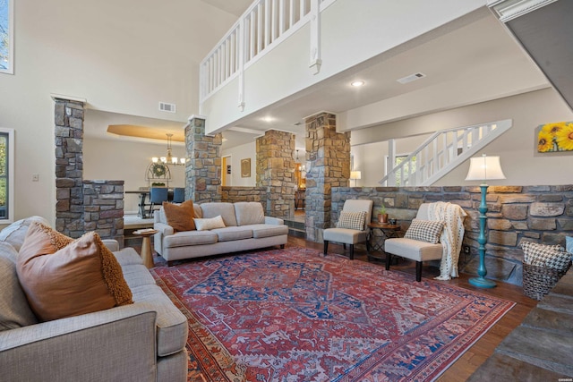 living room with dark wood-type flooring, a healthy amount of sunlight, visible vents, and decorative columns