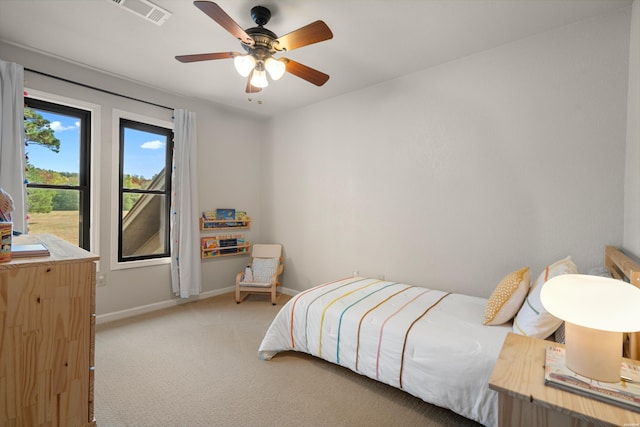 bedroom featuring light carpet, a ceiling fan, visible vents, and baseboards