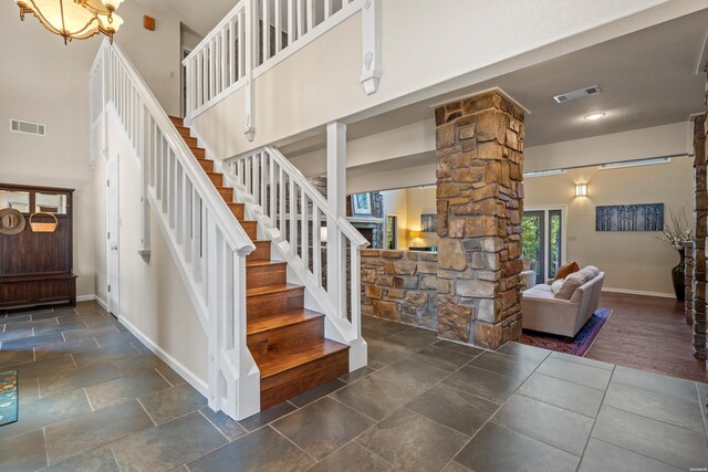 interior space featuring baseboards, a high ceiling, and visible vents