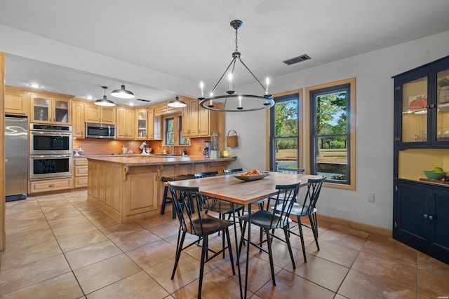 dining room featuring visible vents, a notable chandelier, baseboards, and light tile patterned floors