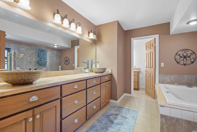 full bath with tile patterned floors, tiled bath, baseboards, and vanity