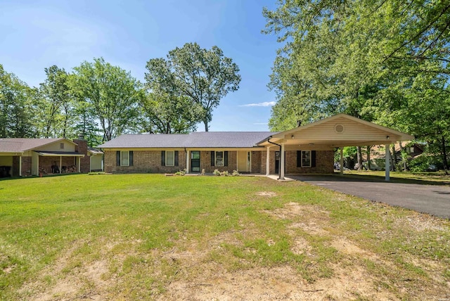 ranch-style home with driveway, brick siding, an attached carport, and a front yard