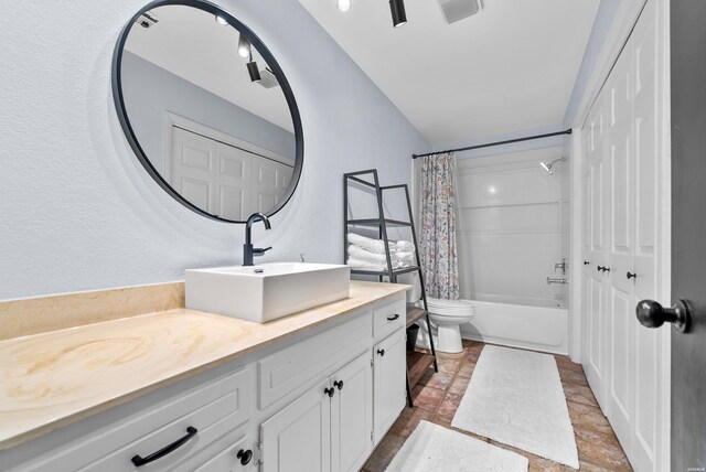 full bathroom featuring toilet, shower / bath combination with curtain, and vanity