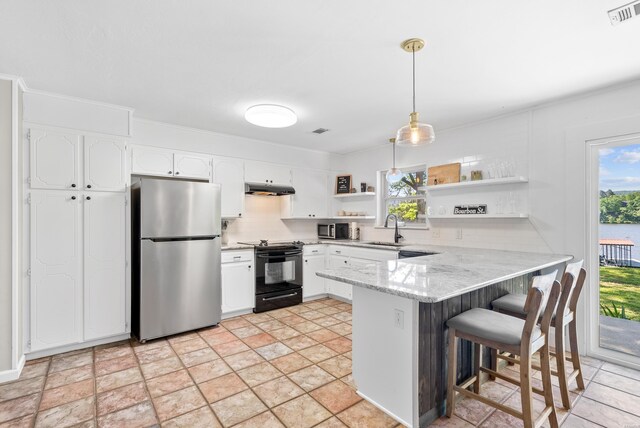 kitchen featuring stainless steel appliances, a peninsula, visible vents, white cabinetry, and decorative light fixtures