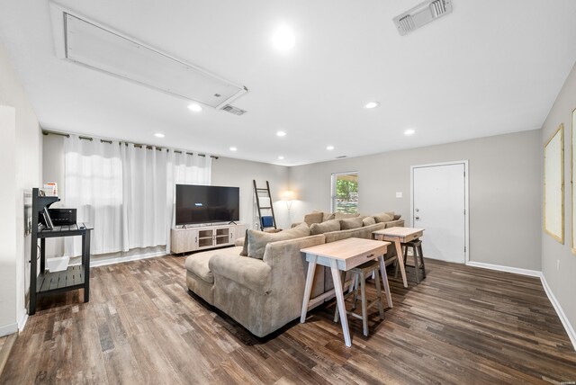 living room featuring attic access, visible vents, and wood finished floors