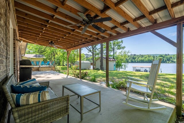 view of patio featuring an outbuilding, a water view, a ceiling fan, grilling area, and a shed