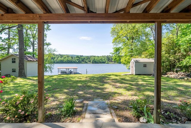 view of yard featuring an outbuilding, a water view, and a storage unit