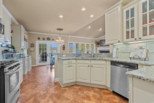 kitchen featuring a sink, decorative backsplash, stainless steel appliances, crown molding, and a chandelier