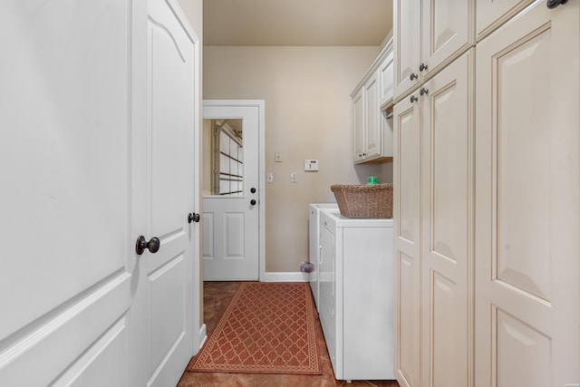 laundry area featuring cabinet space, dark tile patterned flooring, baseboards, and separate washer and dryer