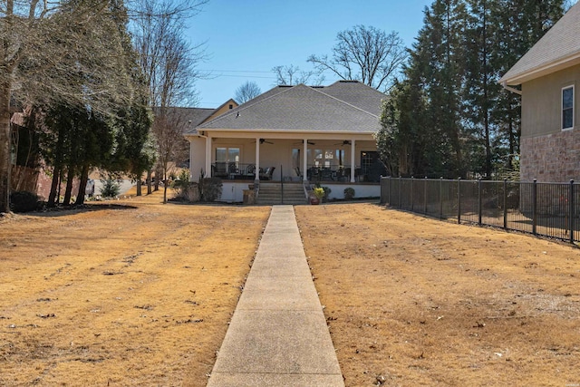 view of front of property with a shingled roof, a ceiling fan, and fence