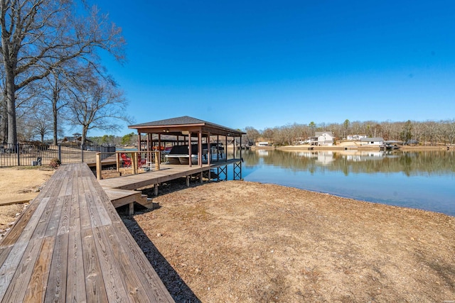 dock area featuring fence, a water view, and boat lift