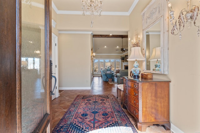 entryway featuring dark tile patterned floors, baseboards, ornamental molding, and ceiling fan with notable chandelier