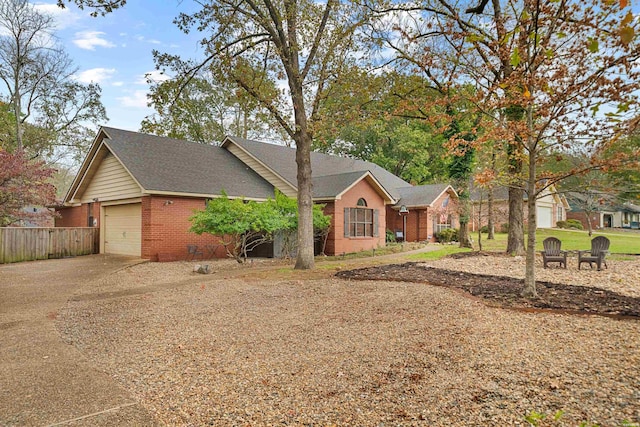 ranch-style home featuring an attached garage, fence, concrete driveway, and brick siding