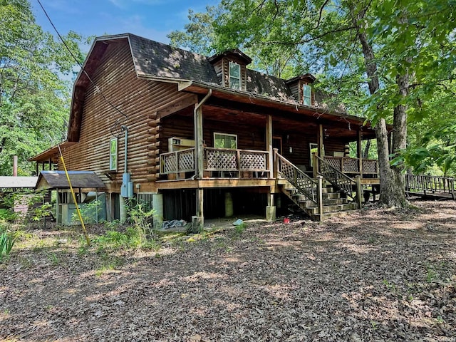 exterior space with stairway, log exterior, and a gambrel roof