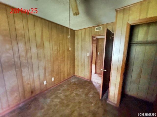501 N Byrd St, Crossett, AR 71635 - unfurnished bedroom with wood walls, carpet floors, and baseboards