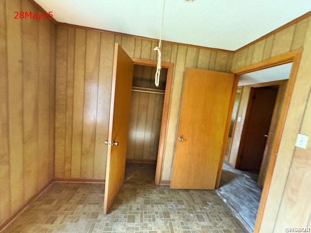 501 N Byrd St, Crossett, AR 71635 - unfurnished bedroom featuring wood walls and brick patterned floors