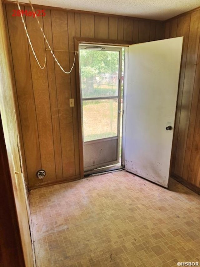 501 N Byrd St, Crossett, AR 71635 - spare room featuring wood walls and a textured ceiling
