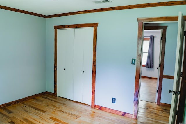 114 Roy Cir, Monticello, AR 71655 - unfurnished bedroom with light wood-style flooring, baseboards, a closet, and ornamental molding