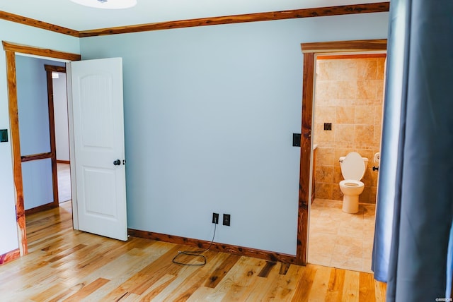 114 Roy Cir, Monticello, AR 71655 - unfurnished bedroom featuring light wood-type flooring, ensuite bath, and baseboards