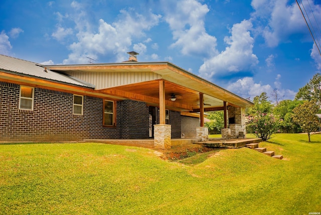114 Roy Cir, Monticello, AR 71655 - back of house with a ceiling fan, a yard, metal roof, and brick siding