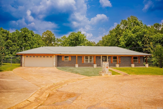 114 Roy Cir, Monticello, AR 71655 - ranch-style house featuring concrete driveway, an attached garage, brick siding, and metal roof