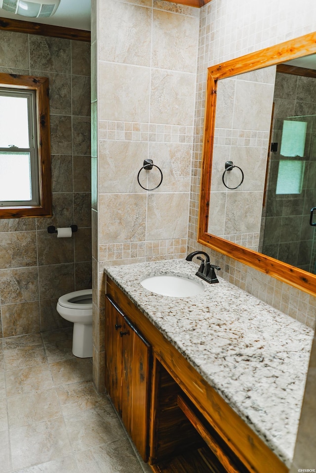 114 Roy Cir, Monticello, AR 71655 - bathroom featuring tile walls, vanity, toilet, tasteful backsplash, and a shower with door