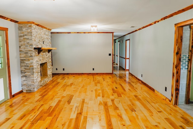 114 Roy Cir, Monticello, AR 71655 - unfurnished living room with wood finished floors, baseboards, crown molding, and a stone fireplace
