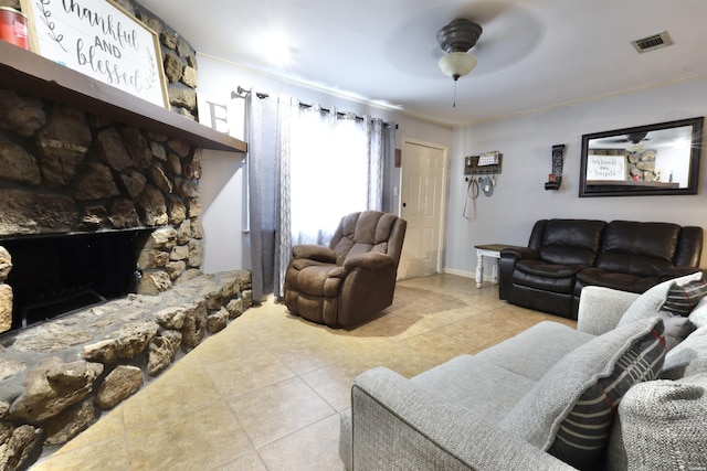 living room with a fireplace, light tile patterned floors, visible vents, a ceiling fan, and baseboards