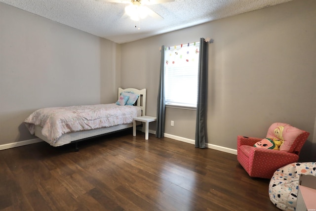 bedroom with ceiling fan, a textured ceiling, baseboards, and dark wood-type flooring