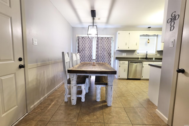 kitchen featuring dishwasher, hanging light fixtures, dark countertops, and white cabinetry