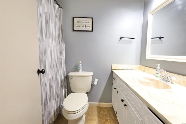 bathroom with vanity, toilet, and baseboards