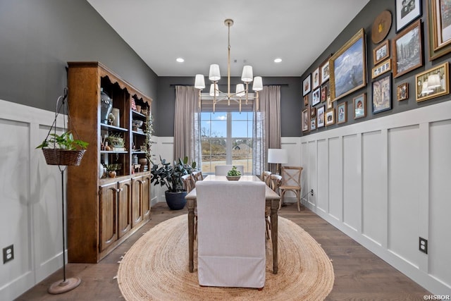 living area featuring an inviting chandelier, a decorative wall, wood finished floors, and recessed lighting