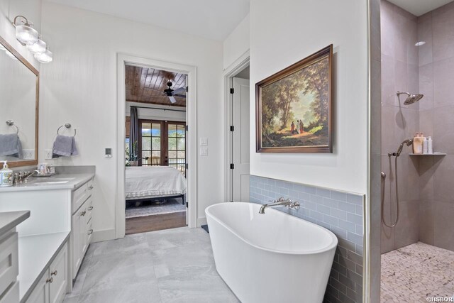 bathroom with connected bathroom, a soaking tub, vanity, a tile shower, and french doors