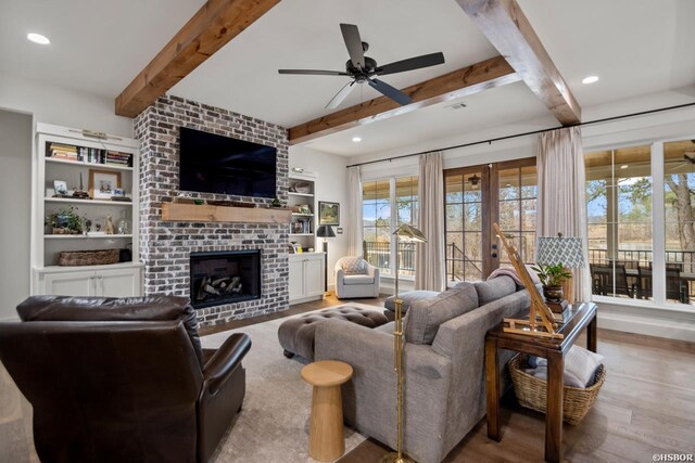 living area with a fireplace, recessed lighting, ceiling fan, light wood-type flooring, and beamed ceiling