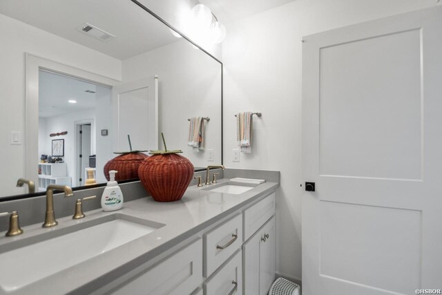 full bath featuring double vanity, a sink, and visible vents