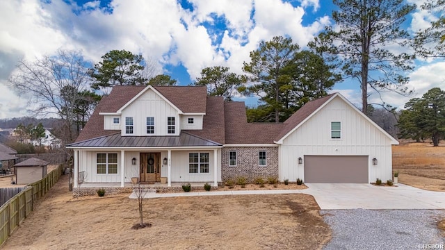 modern farmhouse style home with concrete driveway, metal roof, fence, a porch, and board and batten siding