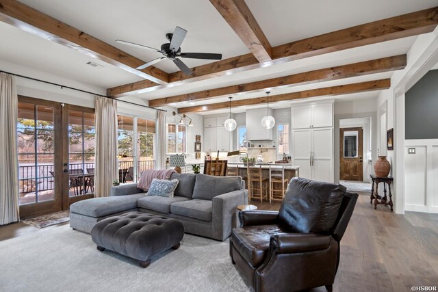 living room featuring beam ceiling, french doors, visible vents, light wood-style flooring, and ceiling fan