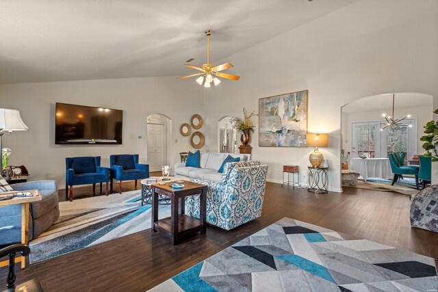 living room featuring arched walkways, dark wood-type flooring, high vaulted ceiling, baseboards, and ceiling fan with notable chandelier