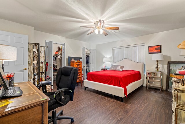 bedroom featuring visible vents, a ceiling fan, a spacious closet, a closet, and dark wood-style floors