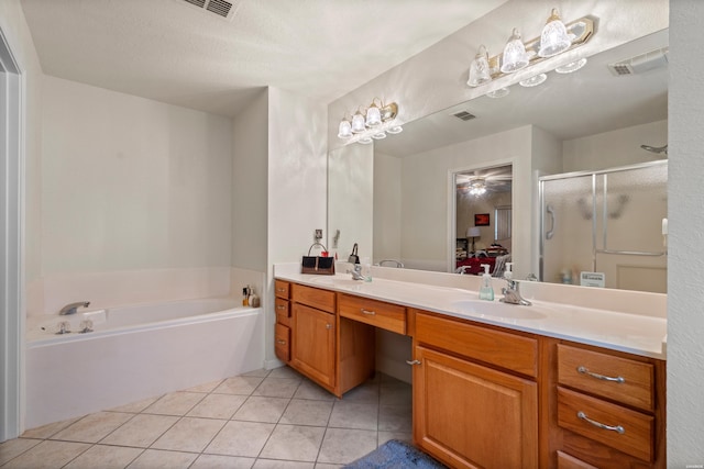 bathroom with double vanity, a garden tub, a sink, and tile patterned floors